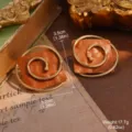 Close-up detail of vintage square gold spiral stud earrings with textured orange base. - Brown Orange Spiral Curve Style (30513A)