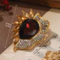 Close-up of vintage gold brooch with large red teardrop gem and colorful rhinestones - Baroque Red Gemstone Style (BR1-0814E-9800)