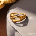 Nahaufnahme eines goldenen geometrischen Edelstahlrings mit Maß- und Gewichtsangaben. - Flüssiger Unregelmäßiger Wellenstil (STR-0011-1800) / Gold