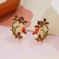 Detailed view of elegant enamel flower and butterfly earrings featuring white pearl accents. - Red Butterfly Red Flower Green Oval Stone Earrings