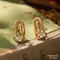 Gros plan de boucles d'oreilles trombone dorées avec cristal et dimensions détaillées - Trombone Doré (2-28284-4800)