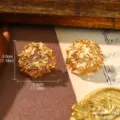 Detailed macro shot of vintage gold filigree stud earrings with intricate ribbon bow motifs - Gold