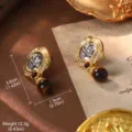 Detailed macro view of vintage coin drop earrings with gold ornate border and dark bead - Portrait Relief Drop Earrings (2-19280A-6500)