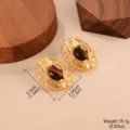 Gros plan détaillé de boucles d'oreilles vintage dorées avec pierre œil de tigre et fleurs - Style Ovale en Relief (E4-19437D-5500)