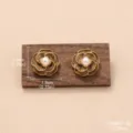 Gros plan détaillé de boucles d'oreilles fleur marron rétro avec perle et tailles - Camélia Café Perle (E4-20499D-5500)