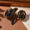 Detailed macro view of an elegant vintage black enamel flower brooch with gold edges - Vintage Black Flower Brooch (BR1-2334A-8800) / Black/Gold
