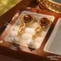 Detailed close-up of vintage gold earrings featuring tiger eye stones and dangling pearls - Vintage Gold Tiger Eye Pearl Style (E4-23357A-7000)