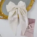 Detail view of the soft white velvet texture on this vintage-style large bow hair clip. - White