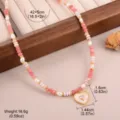 Detailopname van de hartvormige ketting met roze en witte kralen en gouden accenten - Geometrisch Hart Roze Wit Kralen Stijl (5-4645-15300)
