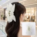 Back view of a woman wearing an elegant white fabric bow hair claw clip in a mall - Off White