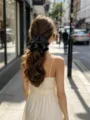 Close-up of elegant black polka dot satin hair bow on a wavy low ponytail - Premium Black