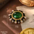 Macro view of vintage green gem brooch with pearls and rhinestones decoration. - Green Gem Black Enamel Brooch (BR1-2560B-6500) / Brooch Style