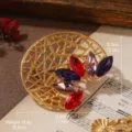 Detailed macro view of vintage geometric gold brooch with colorful crystal petals - Red and Purple Floral Hollow Ring Style (BR1-1295F-7500)