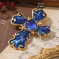 Elegant ornate vintage blue cross brooch with gold filigree and central crystal - Baroque Cross Style (BR1-2564B-7800) / Blue