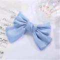 Close-up of shimmering light blue silk bow hair clip on elegant music sheet background - Sky Blue