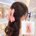 Close-up of elegant pink fabric bow claw clip worn in hair with product detail inset - Dusty Pink