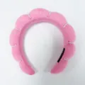 Primer plano de una diadema rosa acolchada con diseño de nube y detalles de perlas. - Rosa fuerte