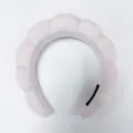 Vista macro detallada de una diadema acolchada rosa decorada con perlas blancas a mano. - Rosa Claro