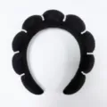Detailopname van een zwarte wolkvormige spons-hoofdband met verfijnde witte parelaccenten. - Zwart