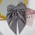 Detail of grey velvet bow hair clip with elegant long ribbons and soft texture - Gray