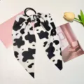 Close-up of the black and white cow print fabric bow hair tie with smooth texture - Bowknot Hair Tie / Cow Print