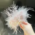 Detailed view of a large pale pink ostrich feather hair claw clip for elegant styling - Pink