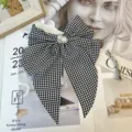 Close-up detail of a vintage houndstooth bow hair clip with elegant pearl center accent - Black and White Houndstooth