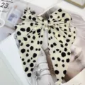 Close-up of a vintage bow hair clip with chic leopard pattern and pearl accents. - Polka Dot