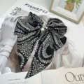 Detailed view of large retro paisley bow hair clip with elegant pearl accents - Black Printed
