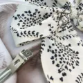Close-up of elegant satin bow hair clip with pearl detail and leopard pattern print - White Floral Print