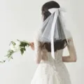 Elegant white bow mesh veil hair accessory shown on the back of a flower girl head - Ribbon Style (F114) / White