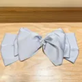 Close-up of a large blue satin bow hair clip with pearl and rhinestone center detail - Blue