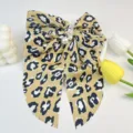 Detailed view of leopard print satin bow hair clip featuring elegant pearl embellishments - Leopard Print