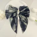 Gros plan d'un nœud en mousseline de soie plissée tie-dye avec embellissement de perles - Smoke Ink