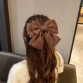 Large brown three-layer bow hair clip with decorative metal buckle on model's hair - With Metal Buckle / Coffee