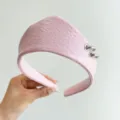 Macro shot of a light pink textured leather headband with stylish silver metal rings - Crown Leather Ring Style / Pink