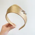 Detail showing the textured golden leather and silver ring accents on the headband. - Crown Leather Ring Style / Gold