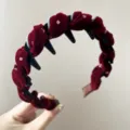 Primo piano di cerchietto in velluto bordeaux con strass e denti antiscivolo. - rosso retrò