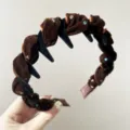 Dettaglio del cerchietto in velluto marrone con strass luccicanti e denti antiscivolo. - Caffè