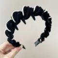 Primo piano di un cerchietto in velluto nero con strass colorati e bordo bianco - Nero