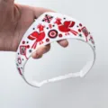 Nahaufnahme der roten und schwarzen Sonnenvogelstickerei auf einem weißen Stirnband - Vogel Stickerei Krone Stirnband (Ohne Schwamm)