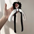 Λεπτομερής λήψη μαύρου βελούδινου scrunchie με μεγάλο λευκό φιόγκο και μακριές κορδέλες - Off-white And Black Bow Streamer Scrunchie