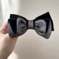 Primo piano di un elegante fermaglio per capelli a fiocco in velluto nero e grigio - Gray and black + bow hairpin