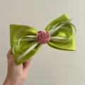 Close-up of a satin green bow hair clip featuring a pink rose center and glossy finish. - Spring Clips / Green with Rose and Bowknot Spring Clip