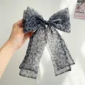 Vue détaillée d'un nœud papillon romantique en résille imprimé léopard gris avec rubans - Nœud pour cheveux / Imprimé Léopard Gris