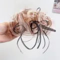 Detailed view of an elegant striped silk gauze hair claw clip decorated with black ribbons - Brown