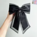 Close-up detail of a large black organza bow hair clip with elegant sheer ribbons - Bowknot Spring Clip / Black