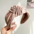 Nahaufnahme der weichen Textur eines geknoteten Satin-Haarreifs in eleganter Cremefarbe. - Knoten Stirnband / Nebelrosa