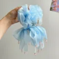 Detail einer hellblauen Haarklammer aus Netzstoff mit rosa Perlen, elegantes Blumendesign. - Blau