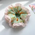 Close-up of sweet candy color ruffled scrunchie with floral print and pleated edge - Green Floral Pleated Edge